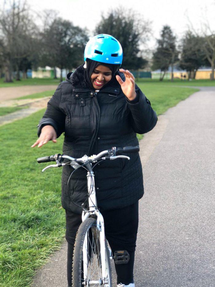 Picture of woman posing with her bike in the park
